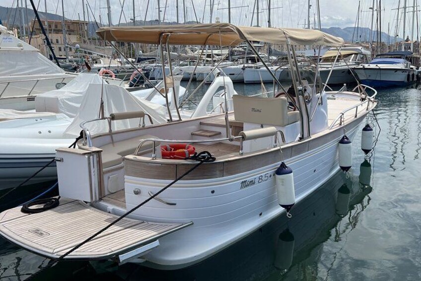 Un bateau à moteur blanc était amarré dans une marina, avec d’autres bateaux en arrière-plan. 2