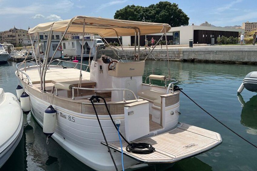 Un petit bateau à moteur était amarré dans une marina. Il était équipé d’un auvent, sa coque était blanche et le nom « MIRANDA 8.5 » était peint sur le côté. 4