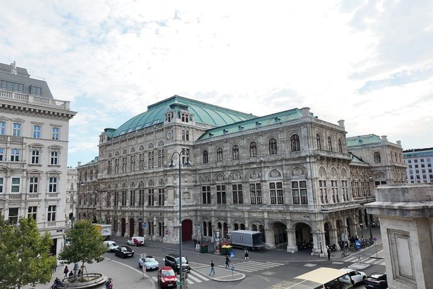 A historic building with a green roof, large windows, and a central entrance. 2