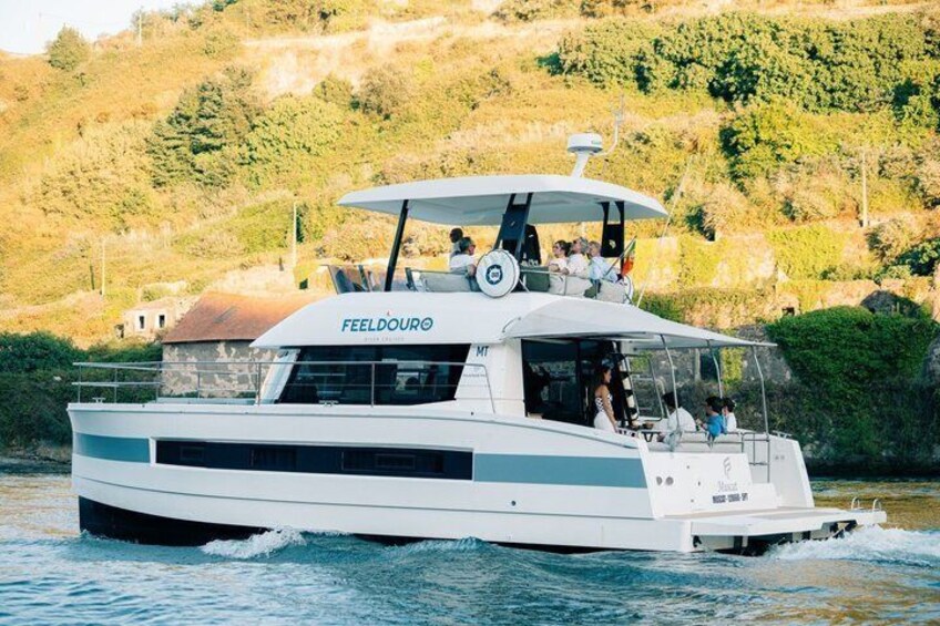 A white boat named FEELDOURO on water with a mountainous landscape in the background. 5