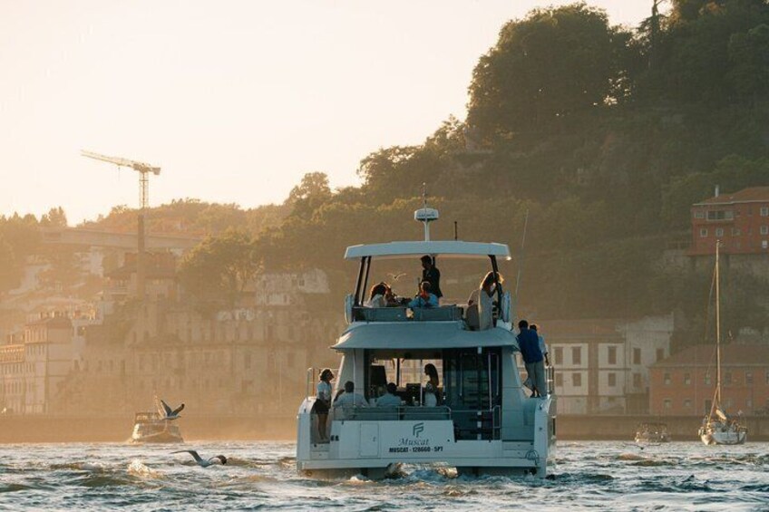 A boat with people on it, water, and buildings in the background. 3