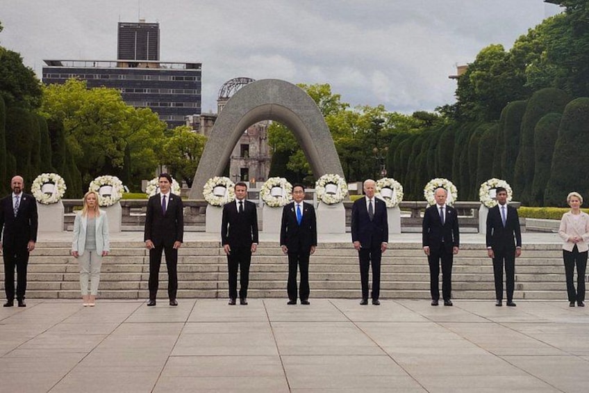 Un grupo de personas frente a un monumento con coronas. 2