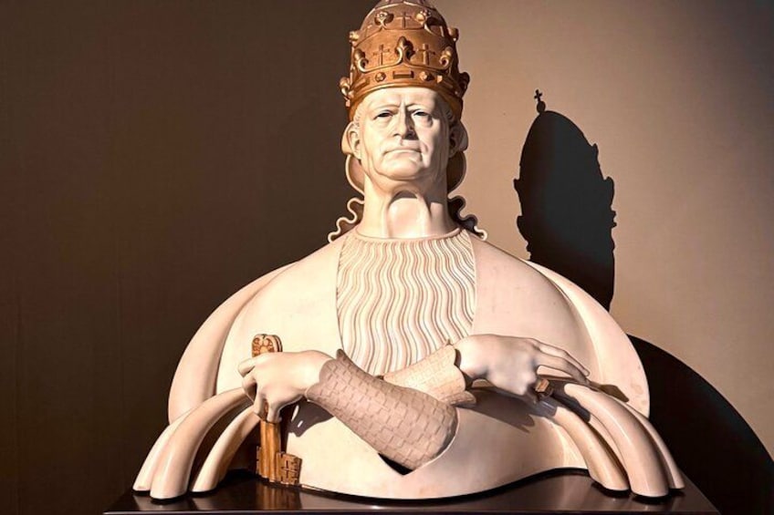 A statue of a person wearing a crown and holding a book. 3