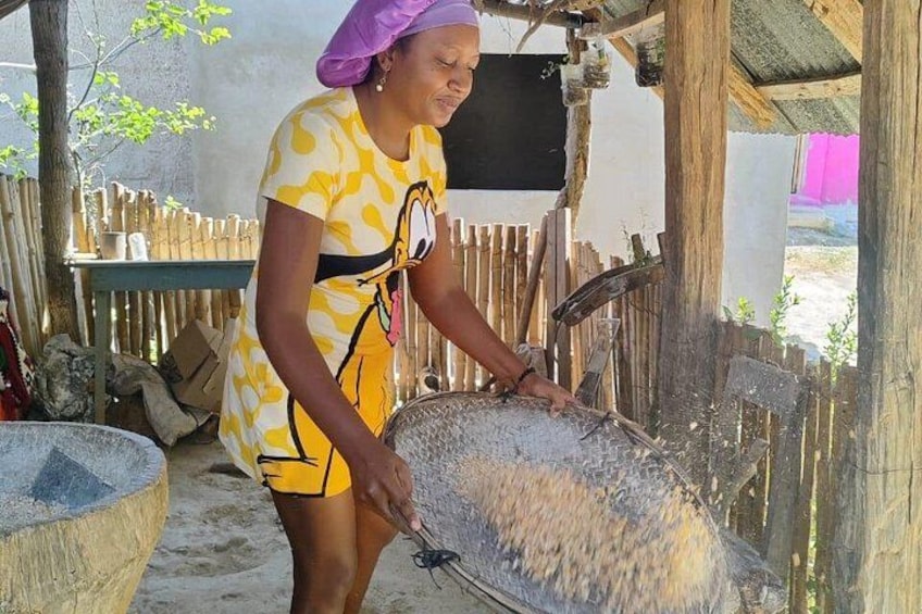 Una persona preparando comida al aire libre, usando una olla metálica grande y una estructura de madera. 4
