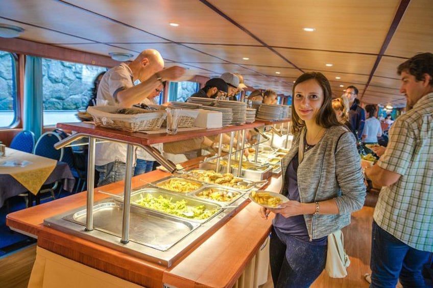 Ein reichhaltiges Buffet mit verschiedenen Speisen und einer Person, die Essen einräumt. 4