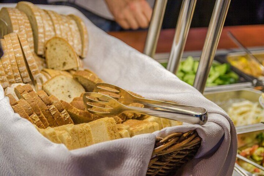 Un buffet avec du pain tranché et des couverts disposés sur une table. 3