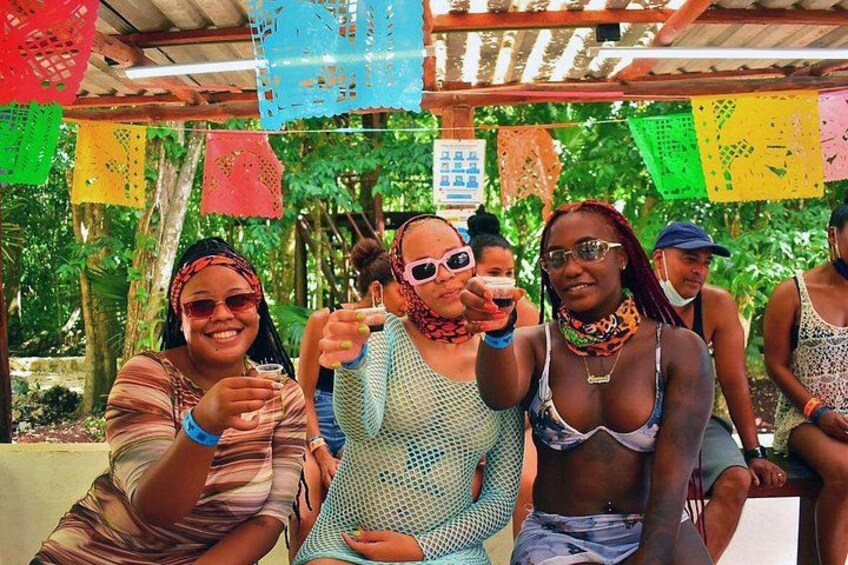 People sitting under a structure with colorful paper decorations. 2