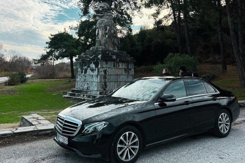 A black car parked in front of a statue in a park. 5