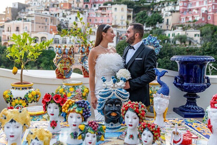 A couple on a rooftop with colorful ceramic heads and vases. 5