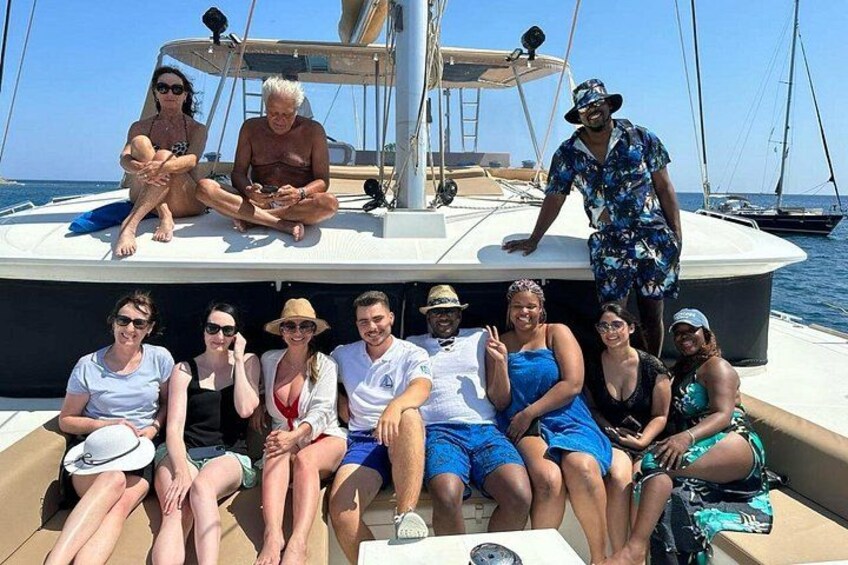 A group of people on a sailboat with a clear sky and calm sea in the background. 4