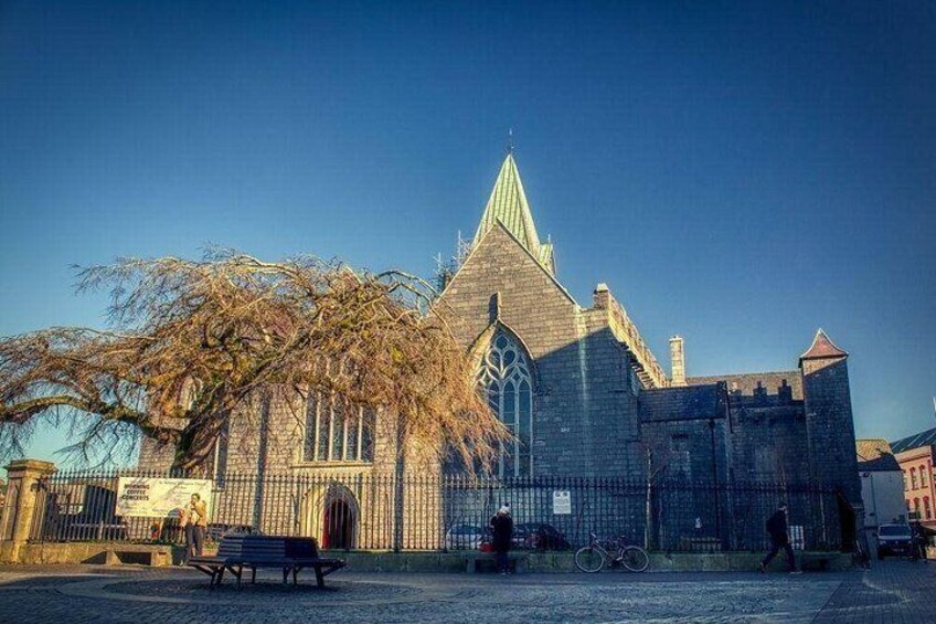 A historic church with a pointed steeple, a large arched window, and a stone facade. 2
