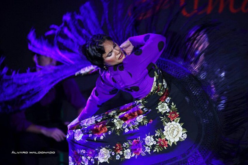 A person in a floral dress performing a dance with dynamic movement. 2