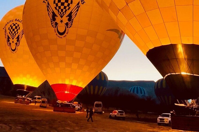 Des montgolfières, une personne et des voitures garées. 3