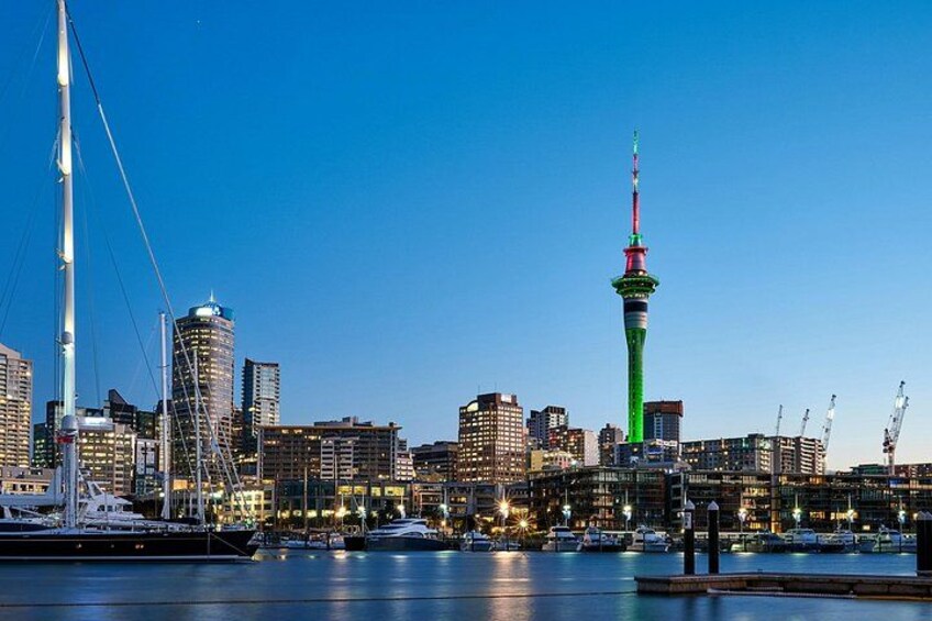 A city skyline with a prominent tower, waterfront, and buildings. 1