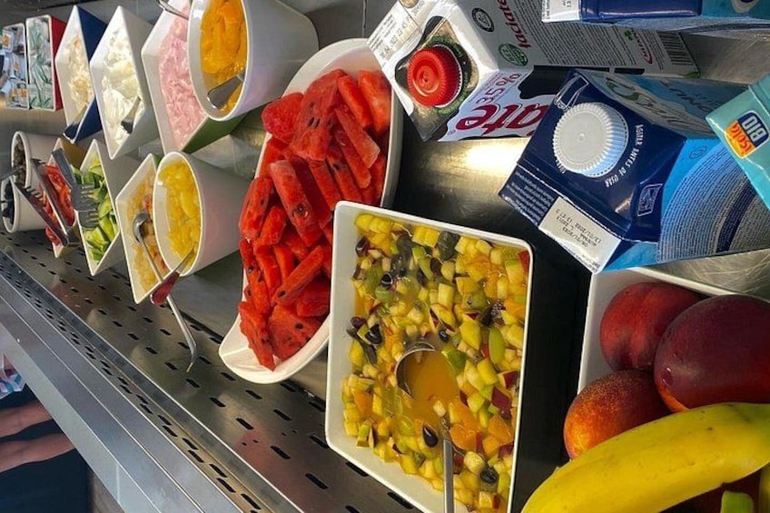 Variedad de frutas y verduras expuestas en un estante con etiquetas y precios. 2
