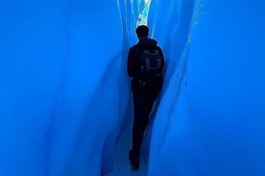 A person walking through a blue tunnel. 4