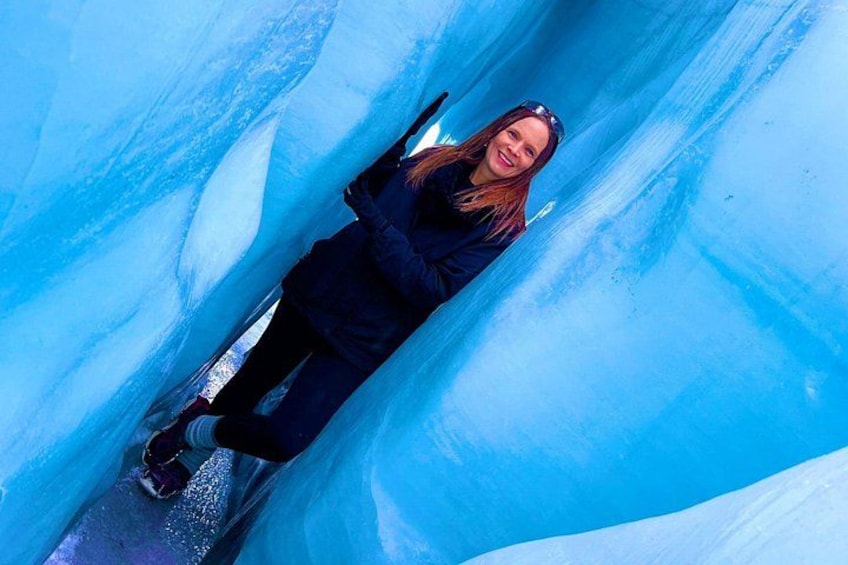 A person skiing down a blue ice tunnel. 1