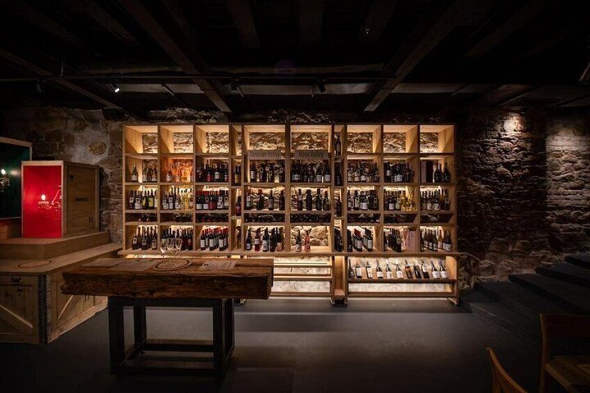 Una cava de vinos con estantes de madera y una mesa central. 1