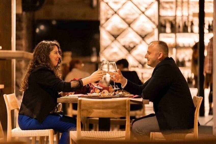 Dos personas sentadas en una mesa en un restaurante, sosteniendo vasos. 1