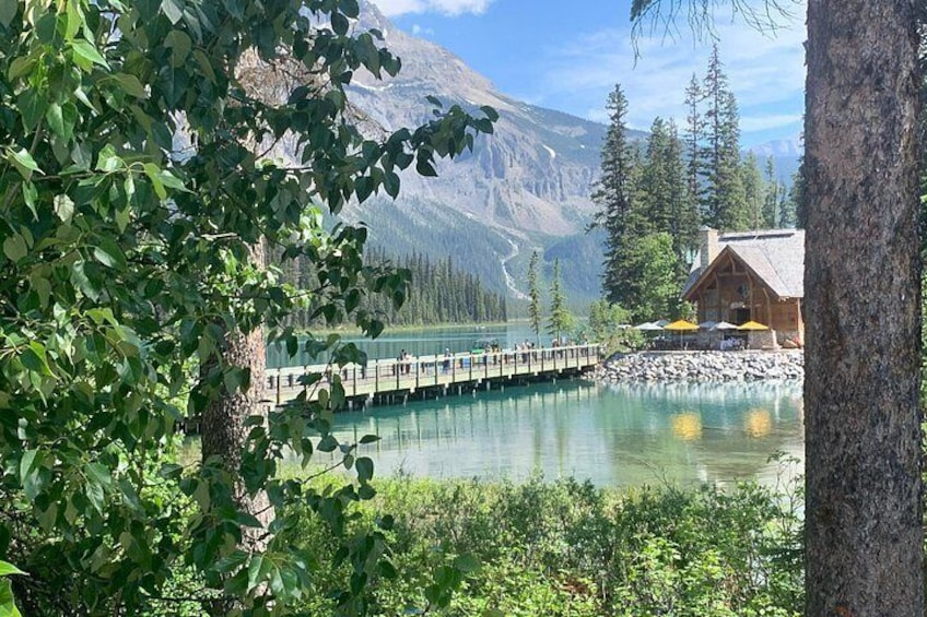 A wooden cabin by a lake with a wooden bridge. 4