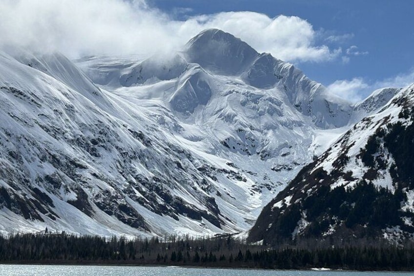 Ein verschneites Gebirge mit einem See am Fuße. 3