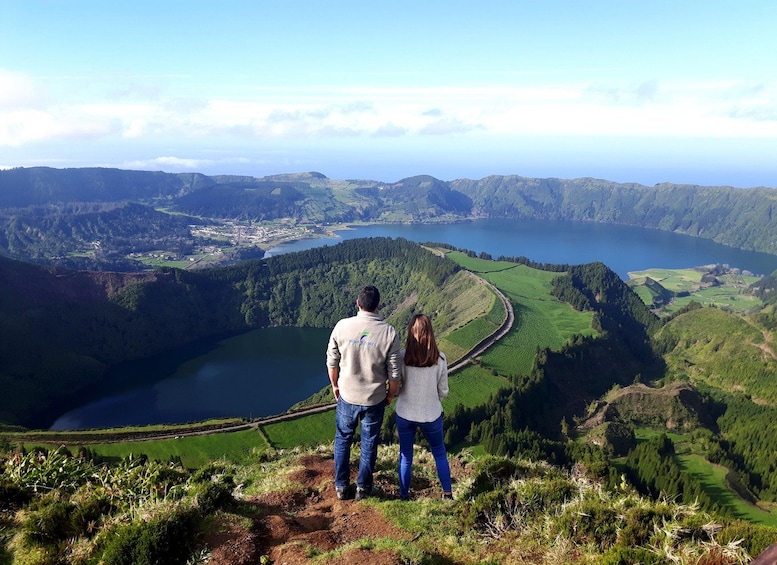 Una coppia in piedi su una collina con vista su una valle, un lago e montagne. 1