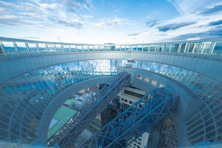A large, circular glass structure with a blue metal framework, likely a part of a modern architectural design. 2