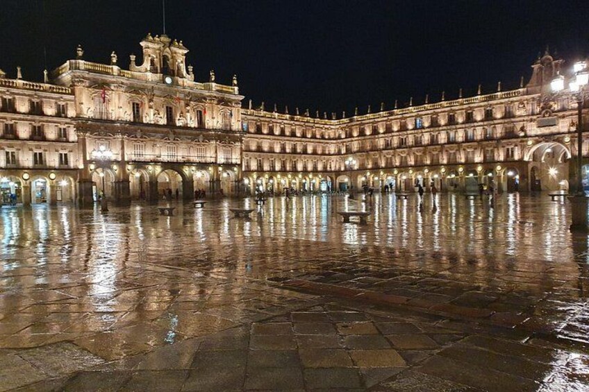 A historic building with a courtyard at night. 1