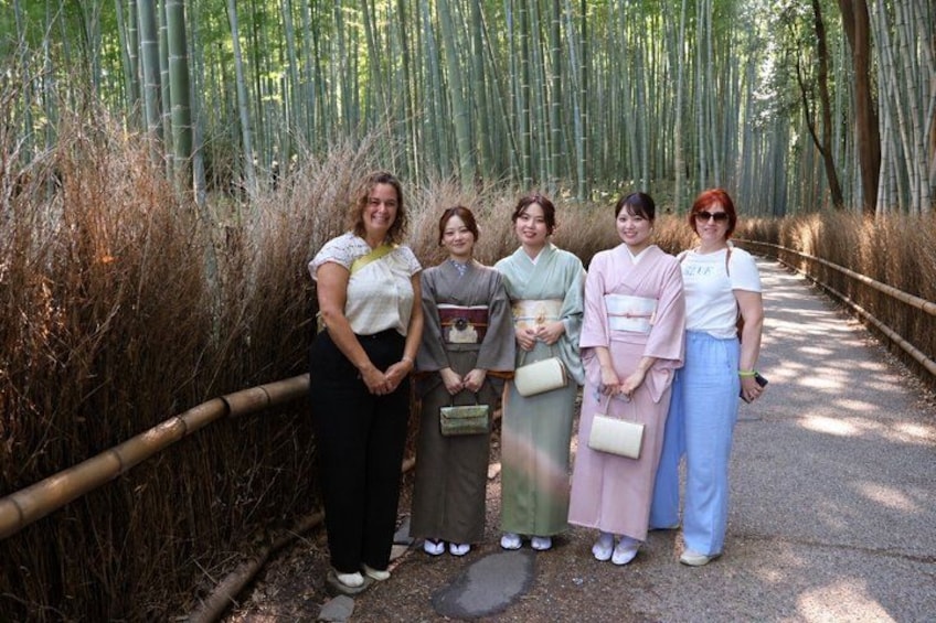 Un gruppo di persone in piedi su un sentiero circondato da bambù. 4