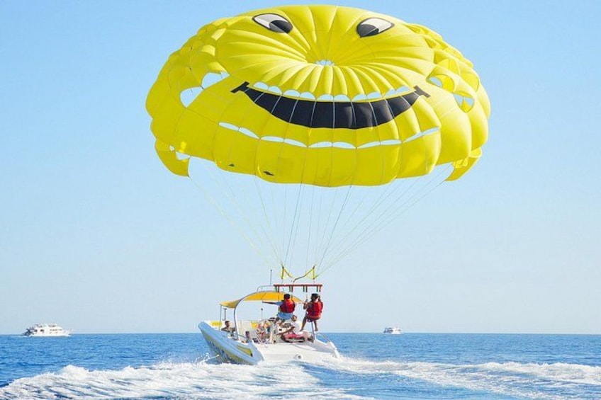 Une activité de parachute ascensionnel avec un parachute jaune, un bateau et l’océan. 5