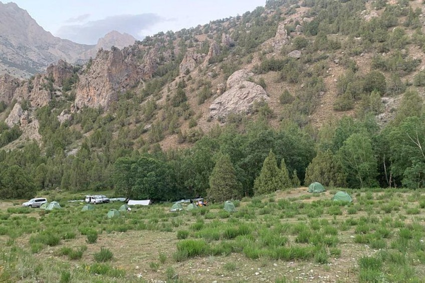 A mountainous landscape with tents and vehicles. 4