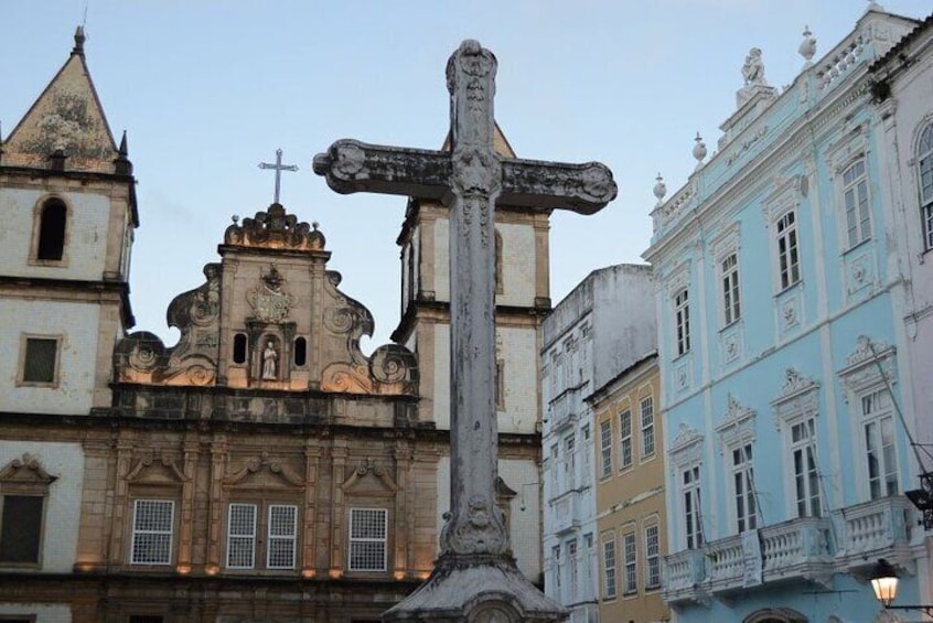 A historic church with a prominent cross, ornate architecture, and adjacent colorful buildings. 5