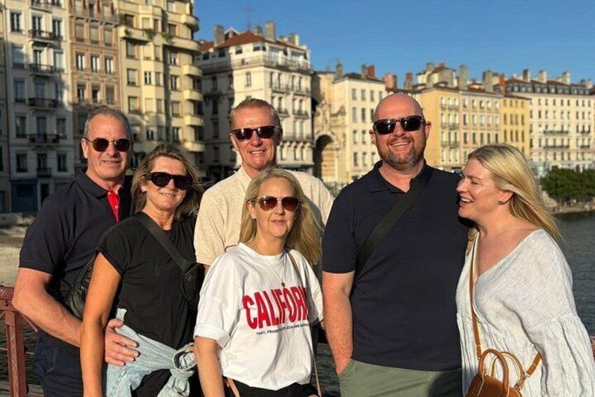 A group of people standing by a waterfront with buildings in the background. 2