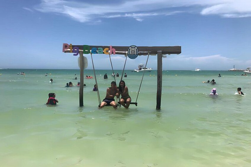 Une plage avec des balançoires et des gens dans l’eau. 5