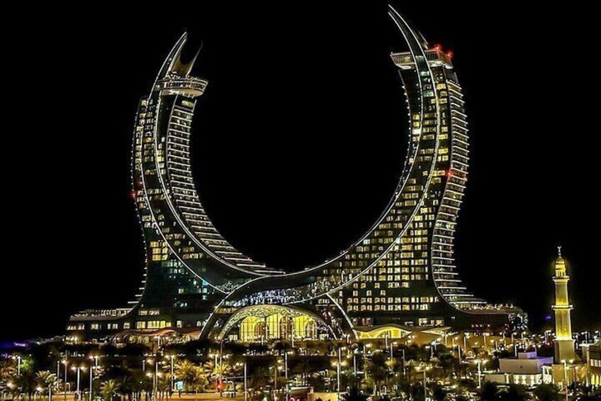 Un edificio brillante en forma de media luna con una torre al final. 3