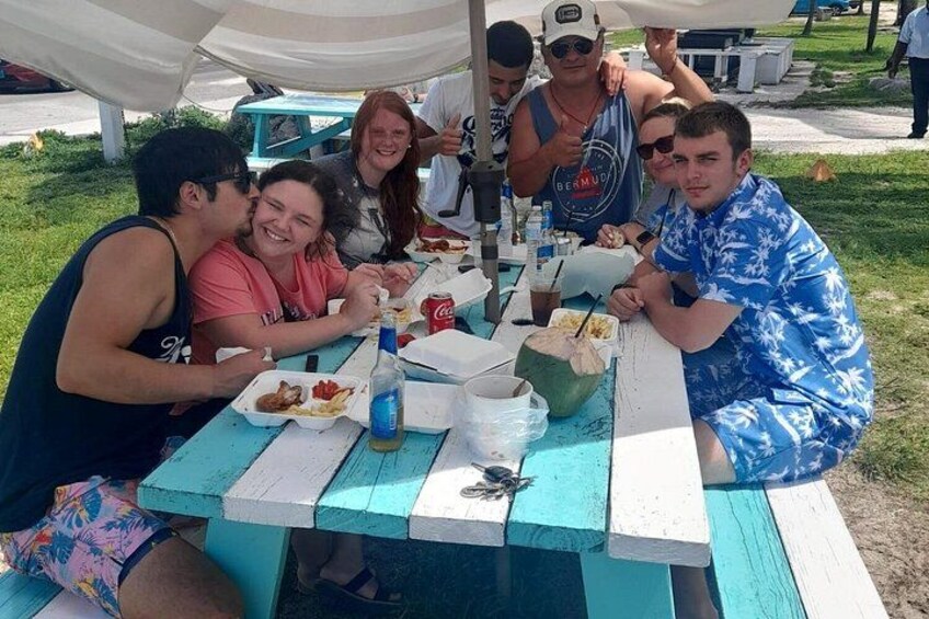 Un grupo de personas sentadas en una mesa de picnic al aire libre. 4