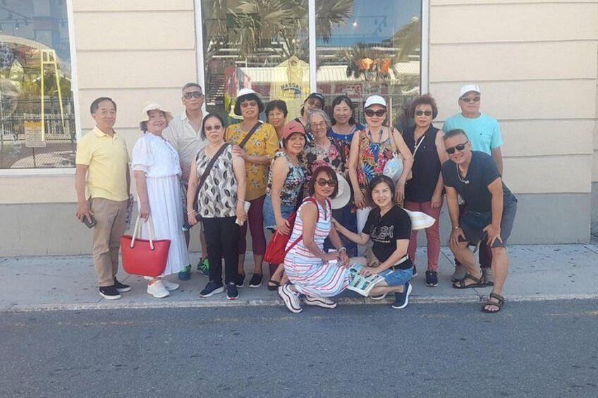 Un grupo de personas posando frente a un edificio con amplias ventanas. 2