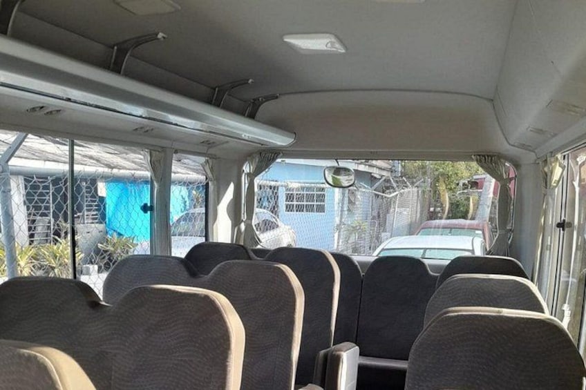 El interior de un autobús con filas de asientos y una ventana. 5