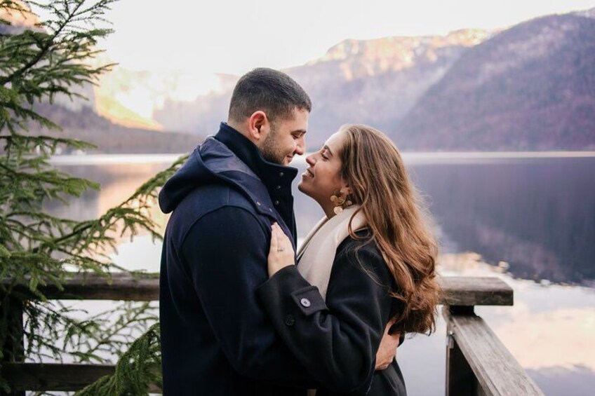 Una pareja abrazándose junto a un lago con montañas al fondo. 2