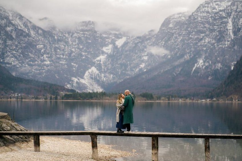 Ein Paar umarmt am Seeufer, im Hintergrund Berge. 2
