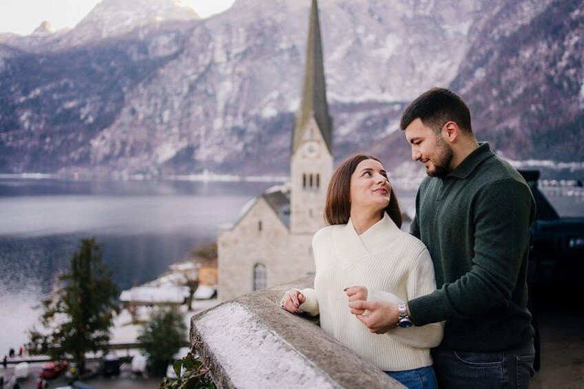 Una pareja de pie junto a un lago, con montañas al fondo. 2