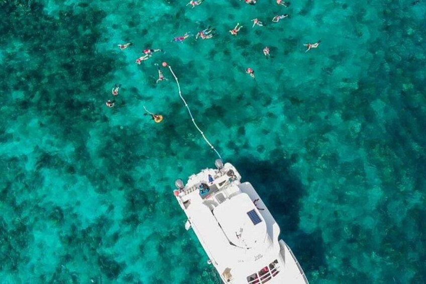 A boat with people swimming in the water. 5