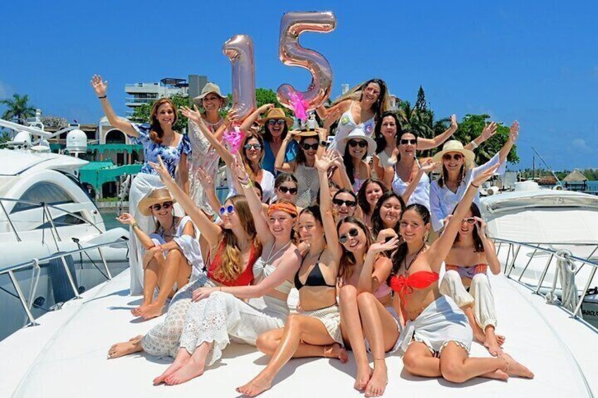 A group of people on a boat with a '15' balloon in the background. 1