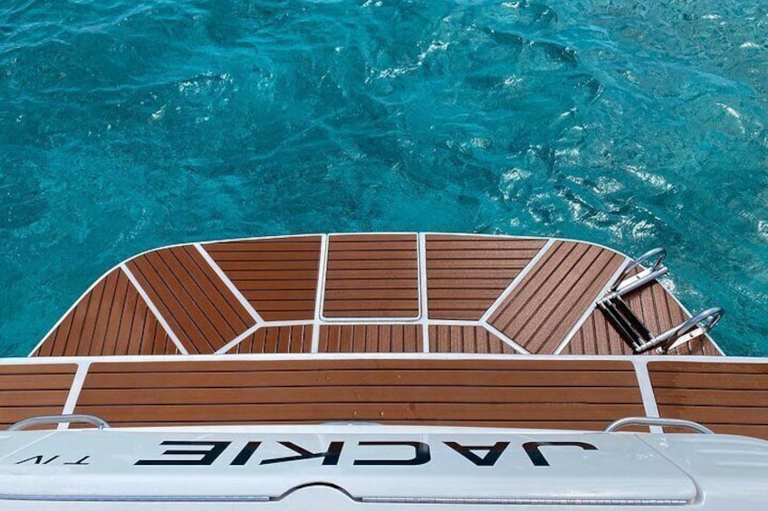 Un bote con cubierta de madera y el nombre 'JACKIE' en el costado. 4