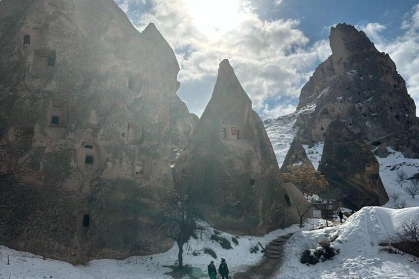 A snow-covered mountainous landscape with rock formations and a narrow path. 3