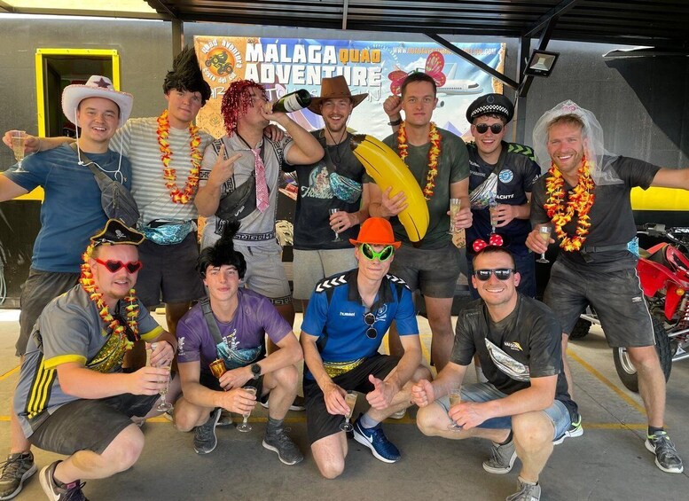 Un groupe de personnes posant devant une banderole pour l'événement « MALAGA ADVENTURE ». 1