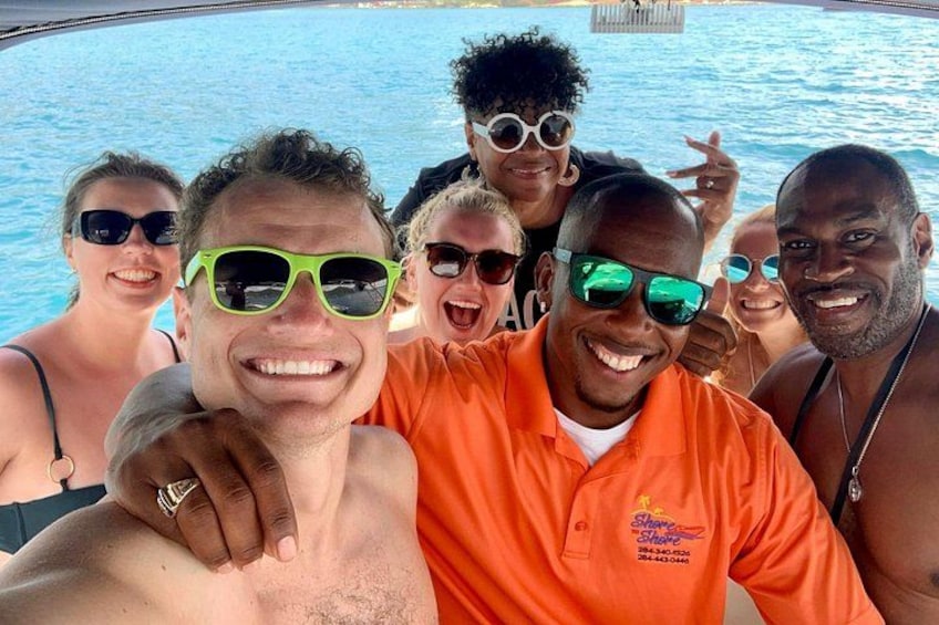 A group of people by a pool, some wearing sunglasses and one in an orange shirt. 5