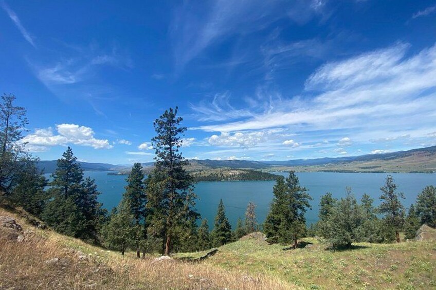 Un lac entouré d’arbres et de collines, sous un ciel dégagé. 5