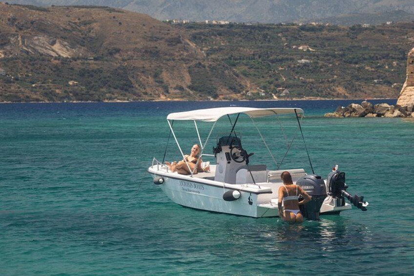 Un petit bateau doté d’un auvent, deux personnes à bord, et une côte rocheuse en arrière-plan. 5