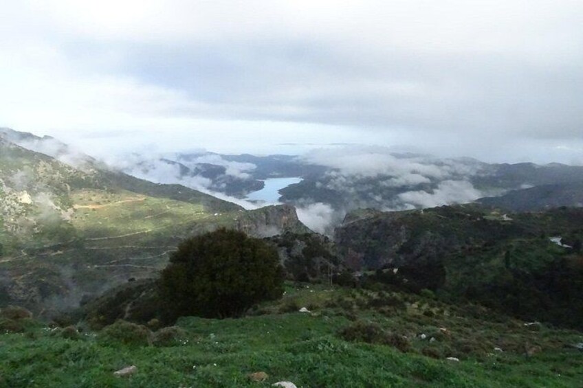 Un paisaje montañoso con un lago rodeado de nubes. 2